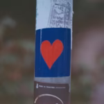Autocollant avec un cœur rouge sur fond bleu symbolisant le sevrage naturel et la bienveillance envers soi