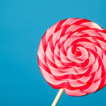 Sucette rouge et blanche sur fond bleu symbolisant une envie de sucre