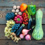 Assortiment de fruits et légumes riches en fibres et à index glycémique bas, posés sur une table en bois