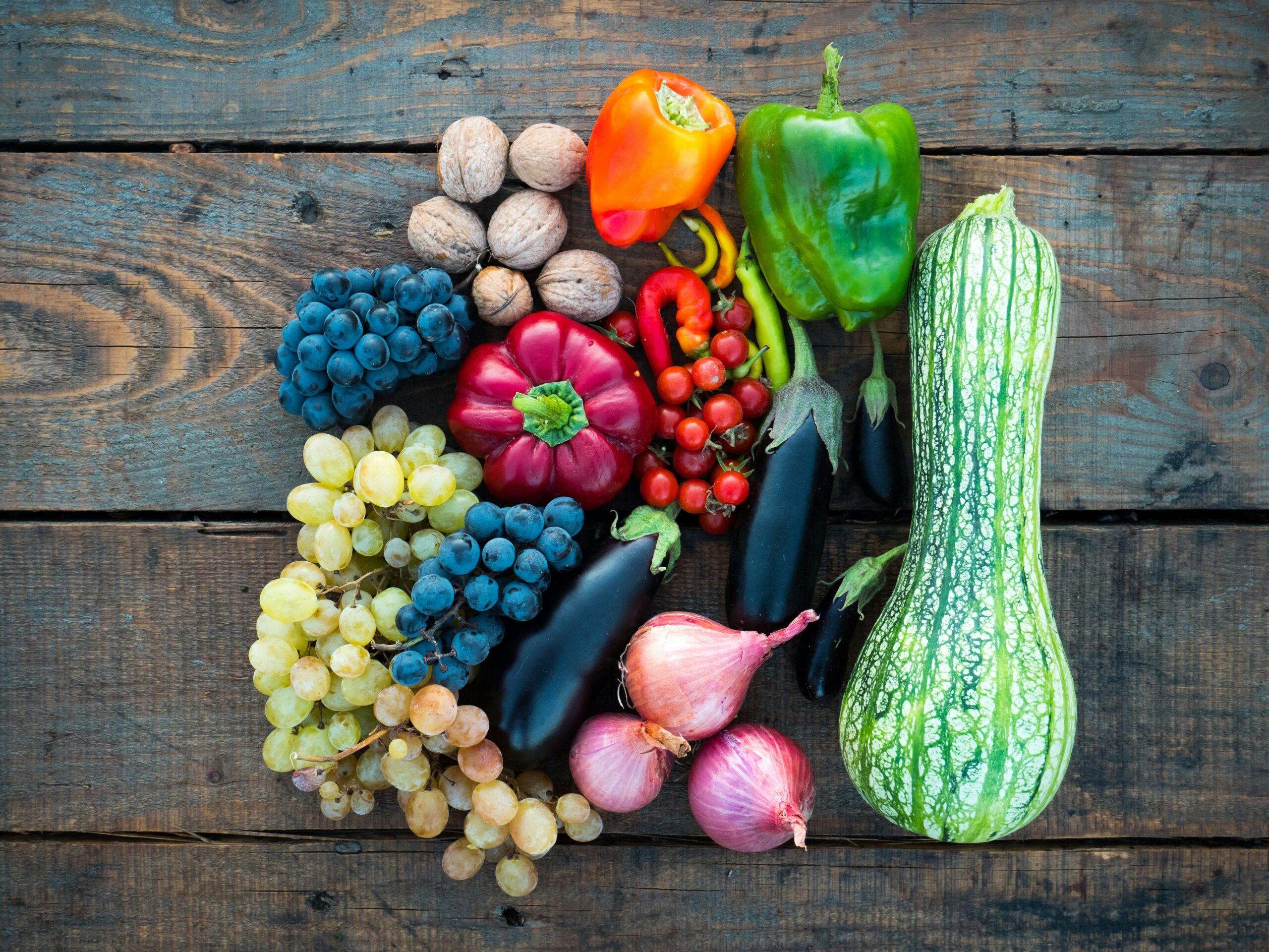 Assortiment de fruits et légumes riches en fibres et à index glycémique bas, posés sur une table en bois