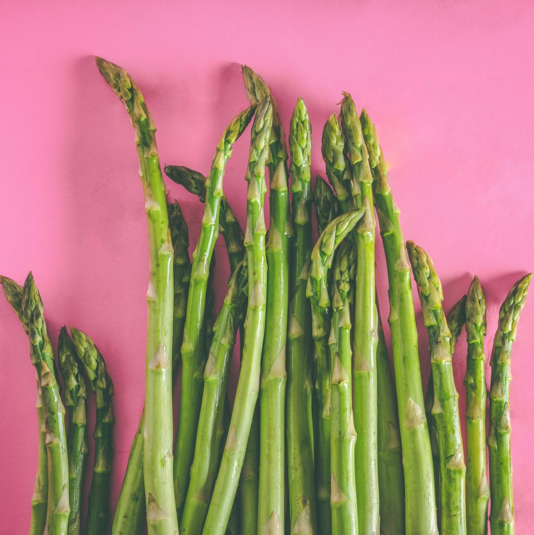 Asperges fraîches sur fond rose – alimentation détox et revitalisante en naturopathie à Biarritz.