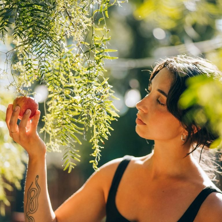 Jeune femme méditant en pleine nature, les yeux fermés, elle se connecte à la santé naturelle